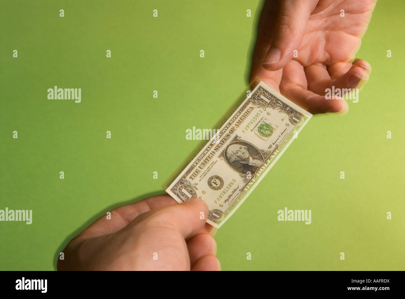 eine Person die Hände zum anderen einer Miniatur USA eine Dollarnote Darstellung die schrumpfenden US-dollar Stockfoto