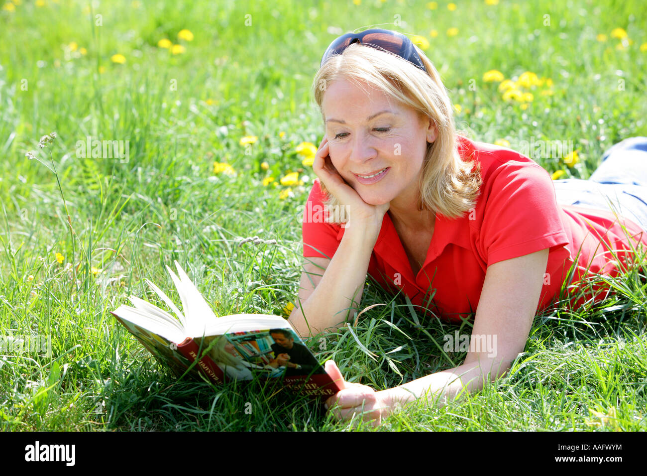Reife Frau Lesebuch draußen im Garten Stockfoto