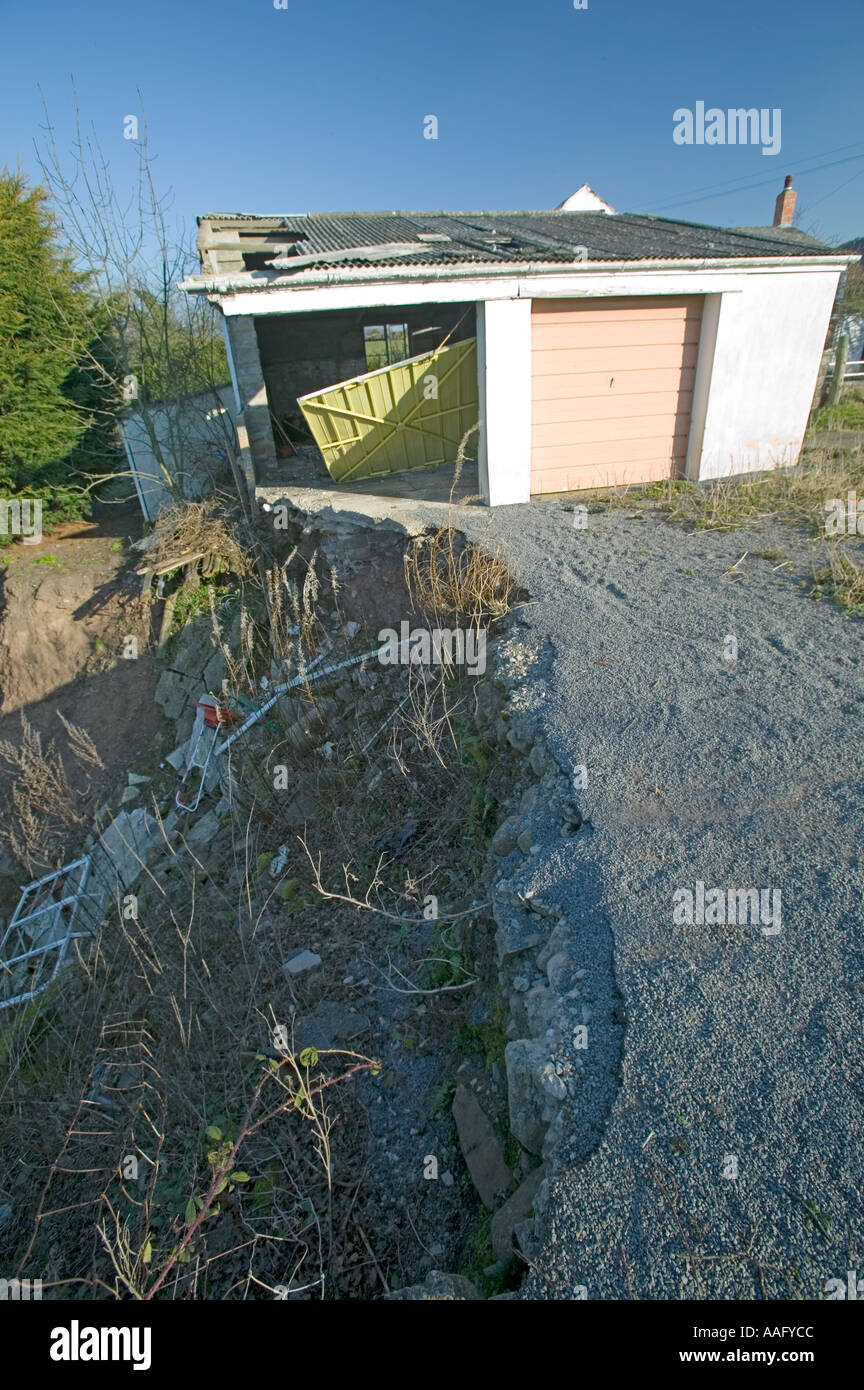Zerstört durch Setzungen, verursacht durch Erosion des Bodens in der Nähe eines Flusses Llanfoist South Wales UK Garage Stockfoto