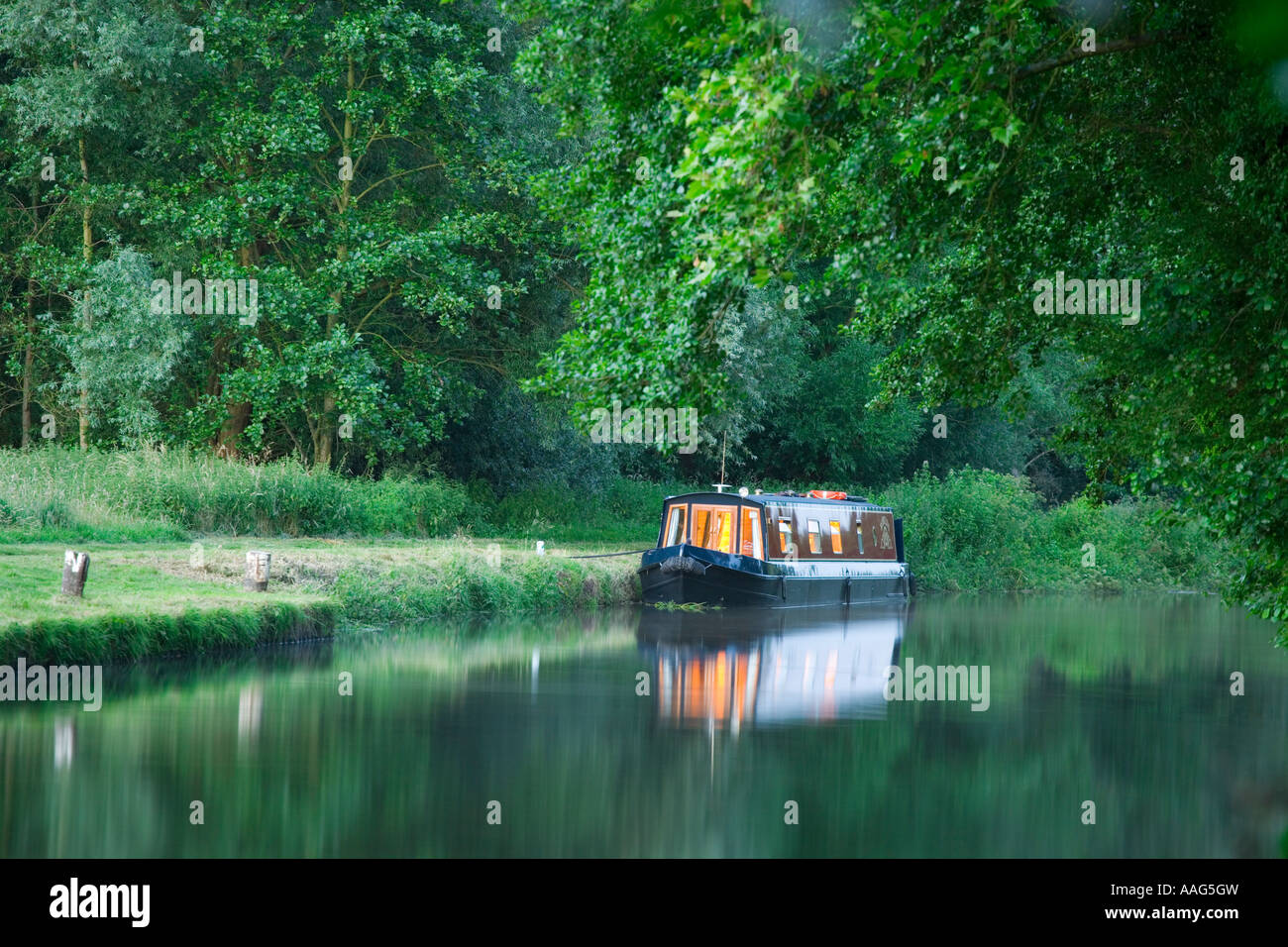 Narrowboat mit Lichtern am Abend am Fluss Wey Navigation in Guildford Surrey UK Stockfoto
