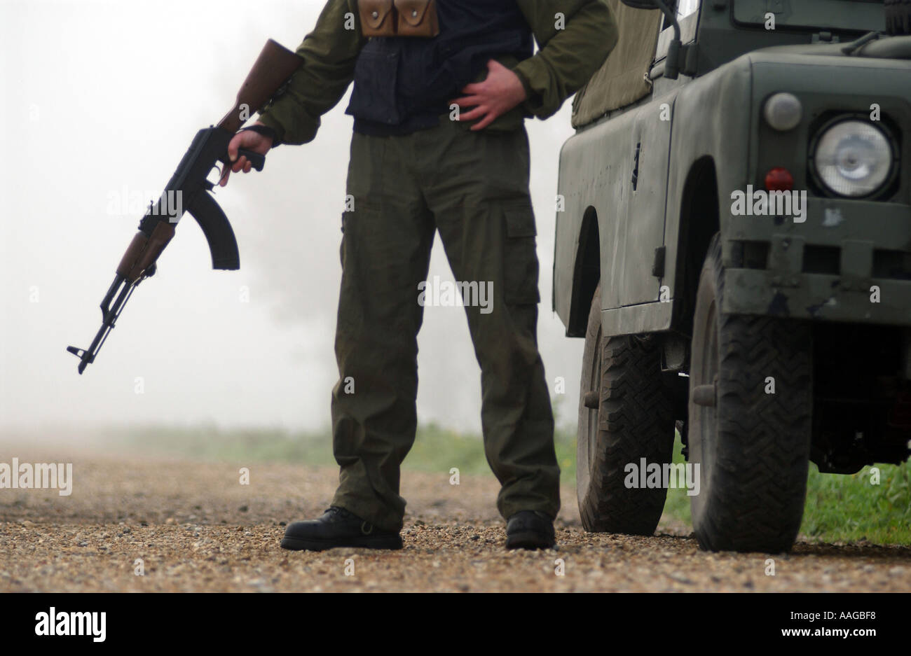 ein Terrorist, gekleidet in eine Sturmhaube hält eine AK47 Kalaschnikow und tragen eines Gürtels von Kugeln neben einem Land rover Stockfoto