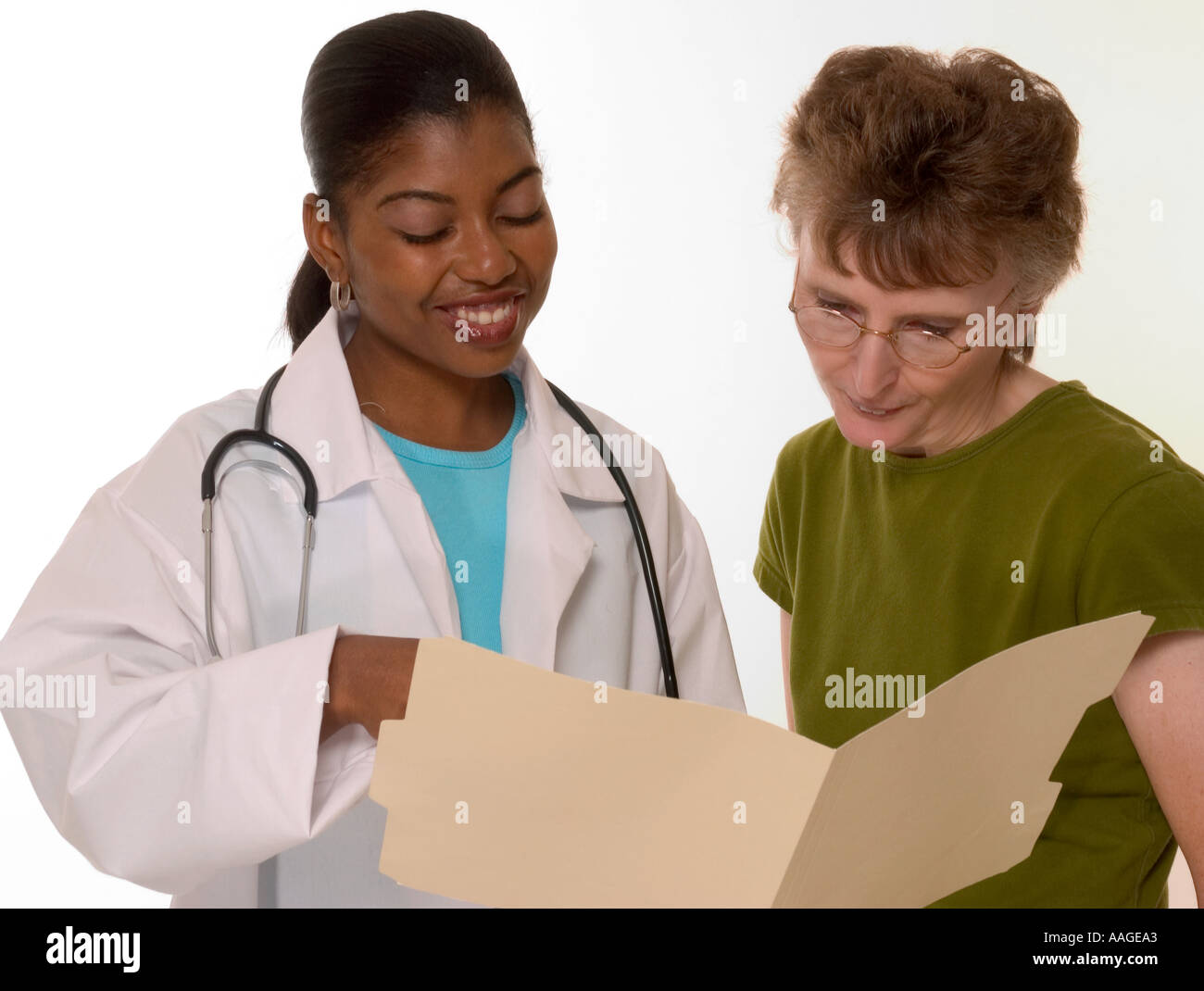 Lächelnde afroamerikanische Ärztin teilt während der Konsultation in den USA positive Testergebnisse mit einer weißen Patientin. Stockfoto