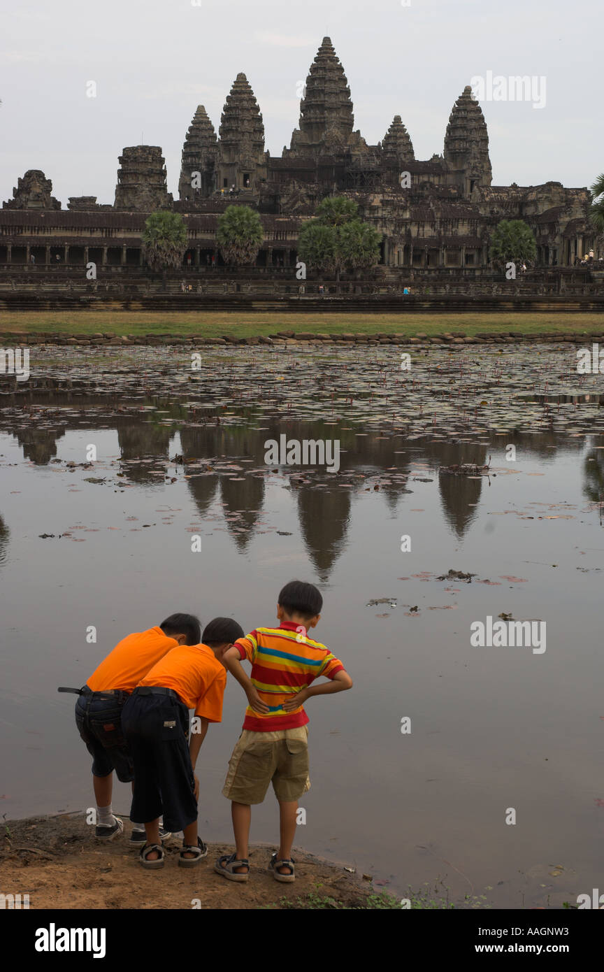 Kambodscha Siem Reap Provinz Tempeln von Angkor Archäologische park Kinder orange Hemd und spielen im Wasser-Teich mit einer Stockfoto