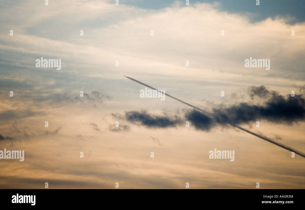 Flugzeuge, so dass ein Kondensstreifen über den frühen Abendhimmel Stockfoto