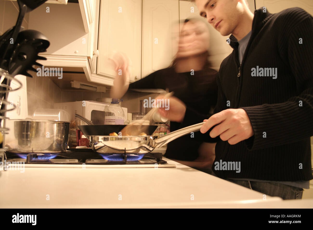 Paar, Kochen in der Küche mit Wok auf Gas-Kochfeld Stockfoto