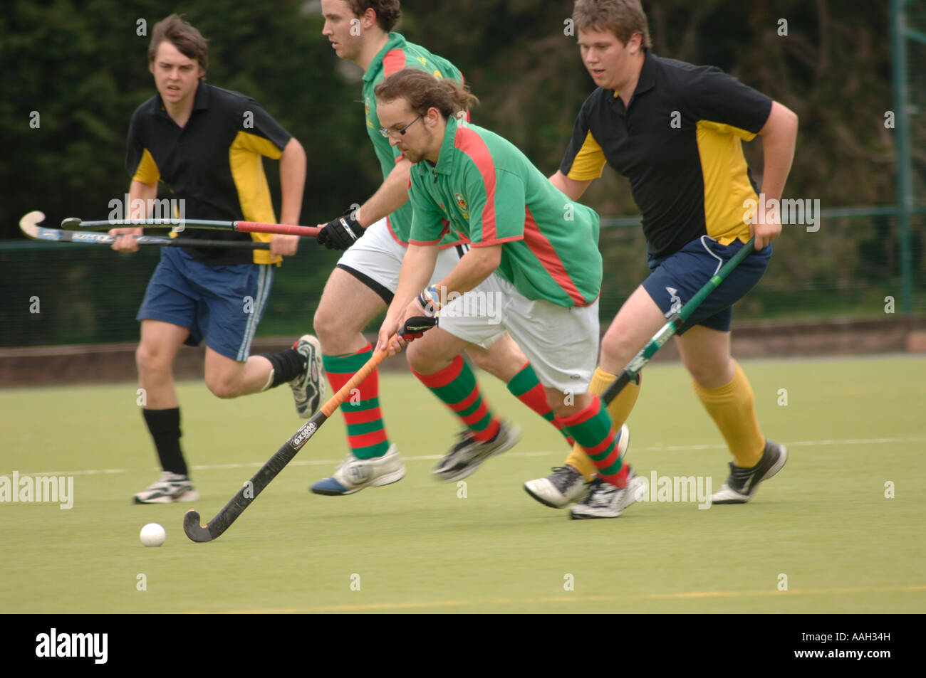 Vier Männer spielen fangen Sie Hockey Spiel Aberystwyth Universität Ceredigion Wales - laufen und angreifen Stockfoto
