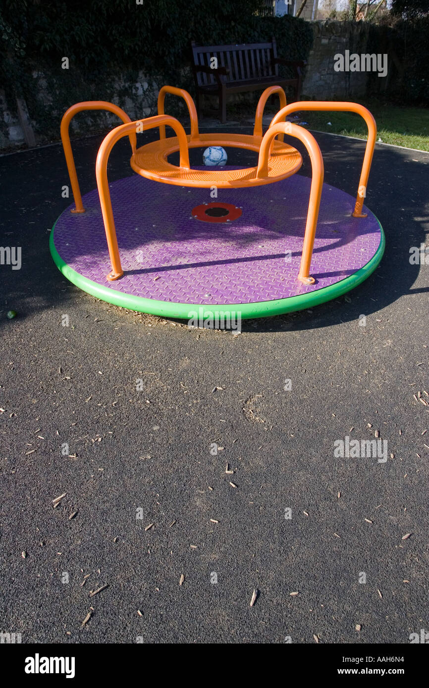 Kleine Runde frohe gehen auf Kinderspielplatz umgeben von Sicherheit Matten hergestellt aus alten Autoreifen UK Stockfoto