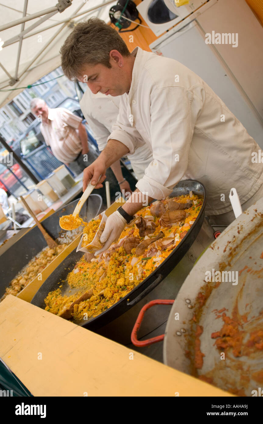 Mann Kochen großen Topf mit Reis und Fleisch Paella auf einem französischen Marktstand in Aberystwyth, Wales Stockfoto