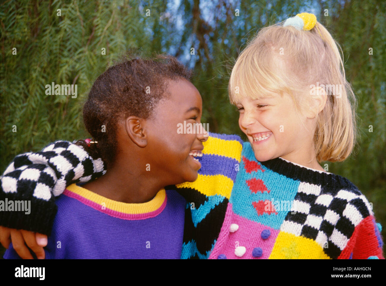 Mädchen 6 7 jährige mit Arm um Freund lächelnd auf Regentag ethnisch ethnische Vielfalt multikulturellen Multi kulturelle Herr © Myrleen Pearson Stockfoto