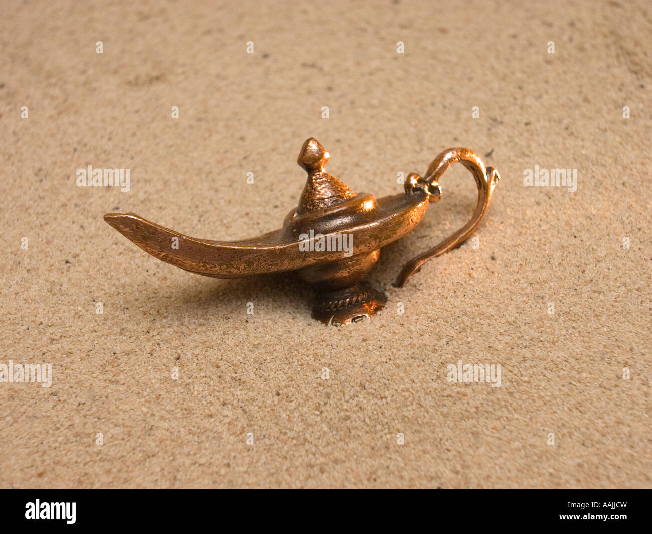 Genie-Lampe, die teilweise im Sand begraben Stockfoto