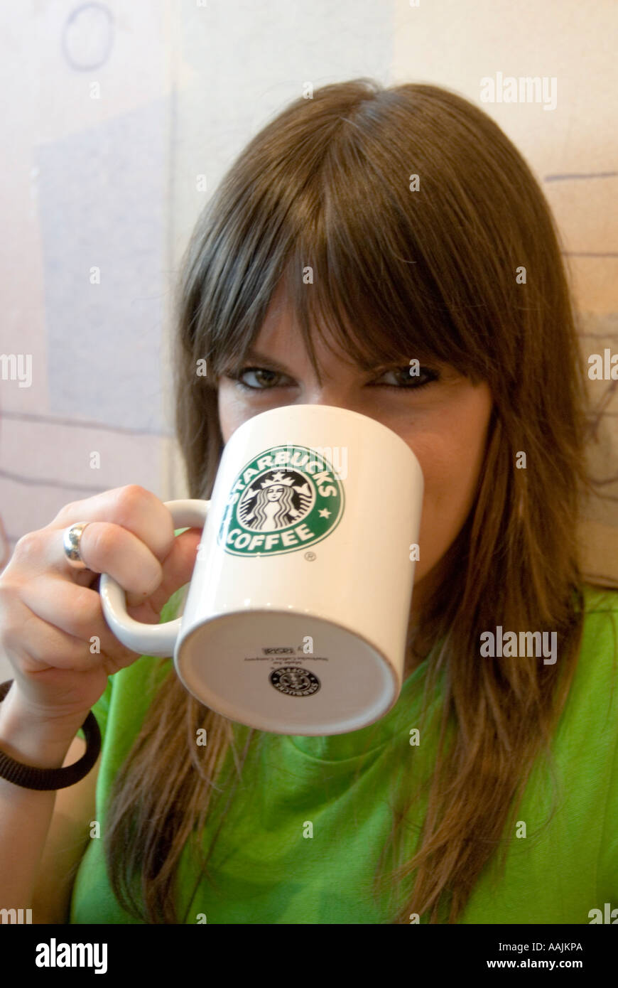 Junge Frau trinken Kaffee bei Starbucks, England Großbritannien UK Stockfoto
