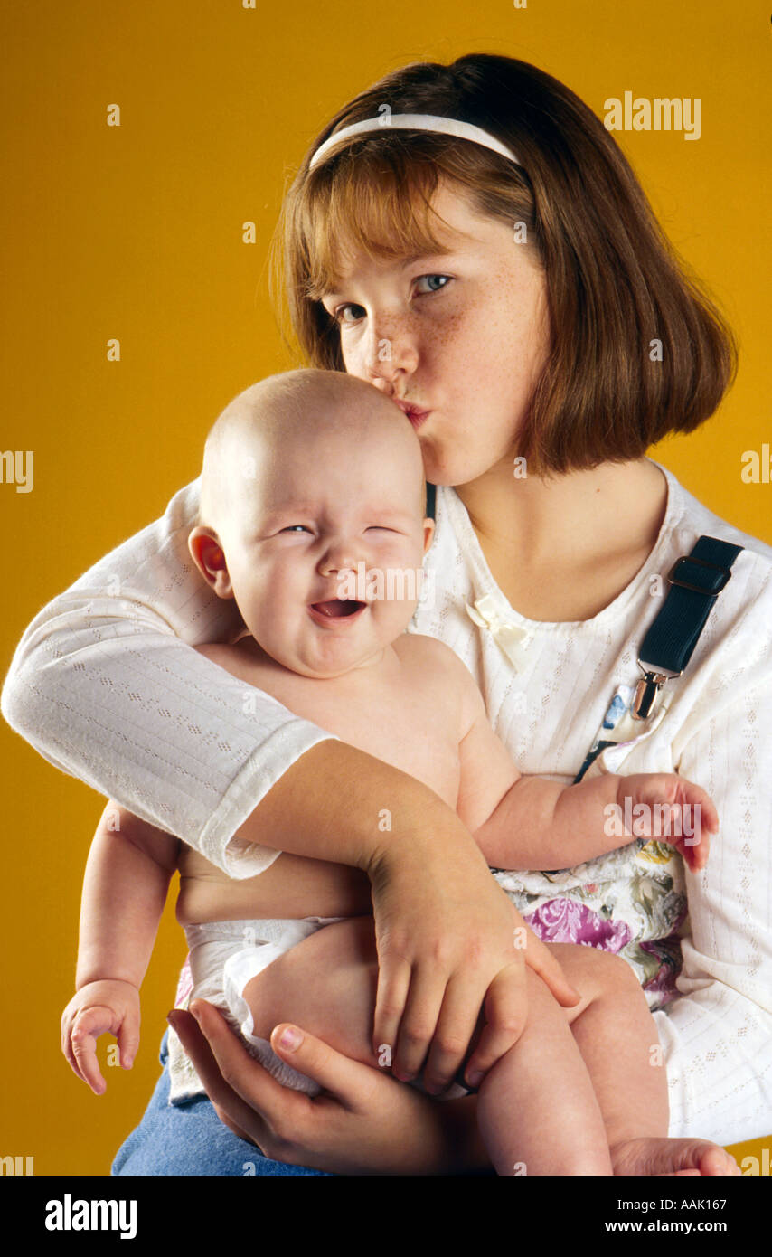 Junge Mädchen küssen Babyschwester Stockfoto