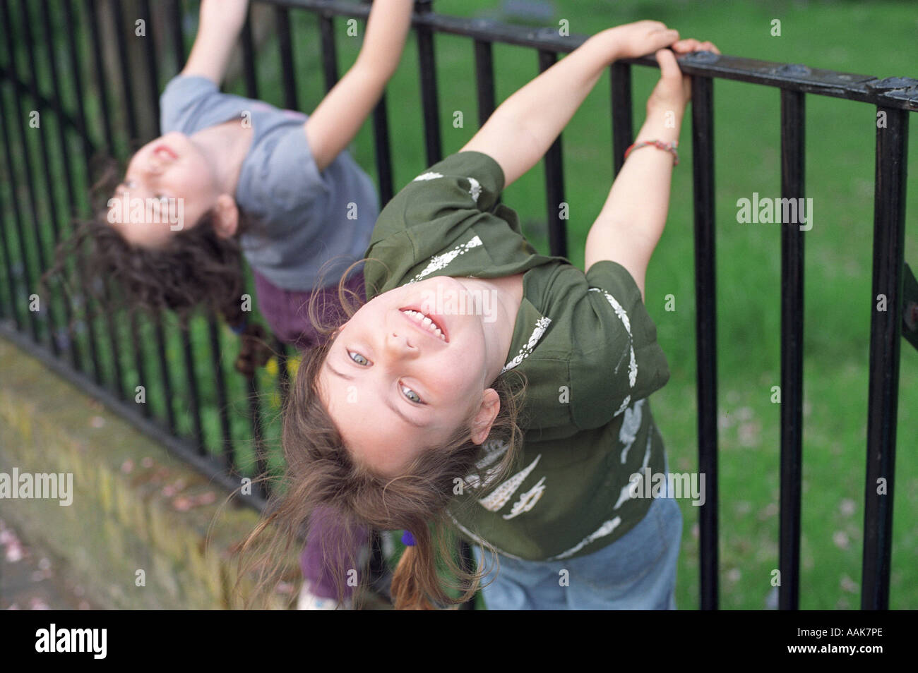 Zwei sechs Jahre alten Mädchen spielen auf Metallgeländer, London, UK. Stockfoto