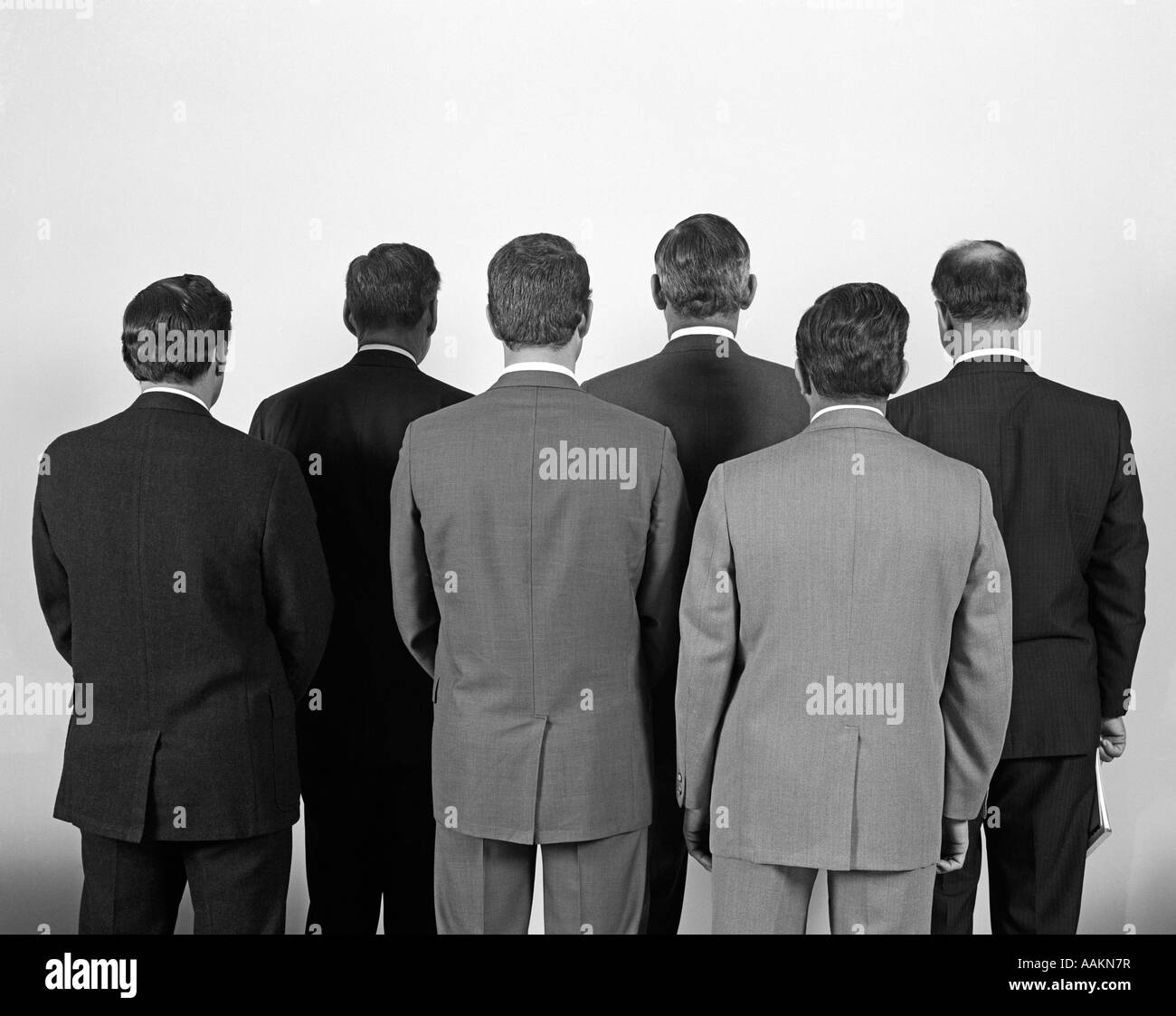 1960ER JAHREN RÜCKANSICHT DER SECHS GESCHÄFTSLEUTE Stockfoto