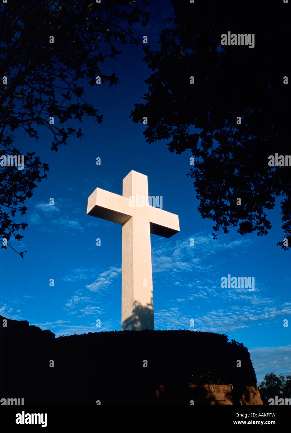 WEIßES KREUZ AUF HÜGEL GEGEN BLAUEN HIMMEL Stockfoto