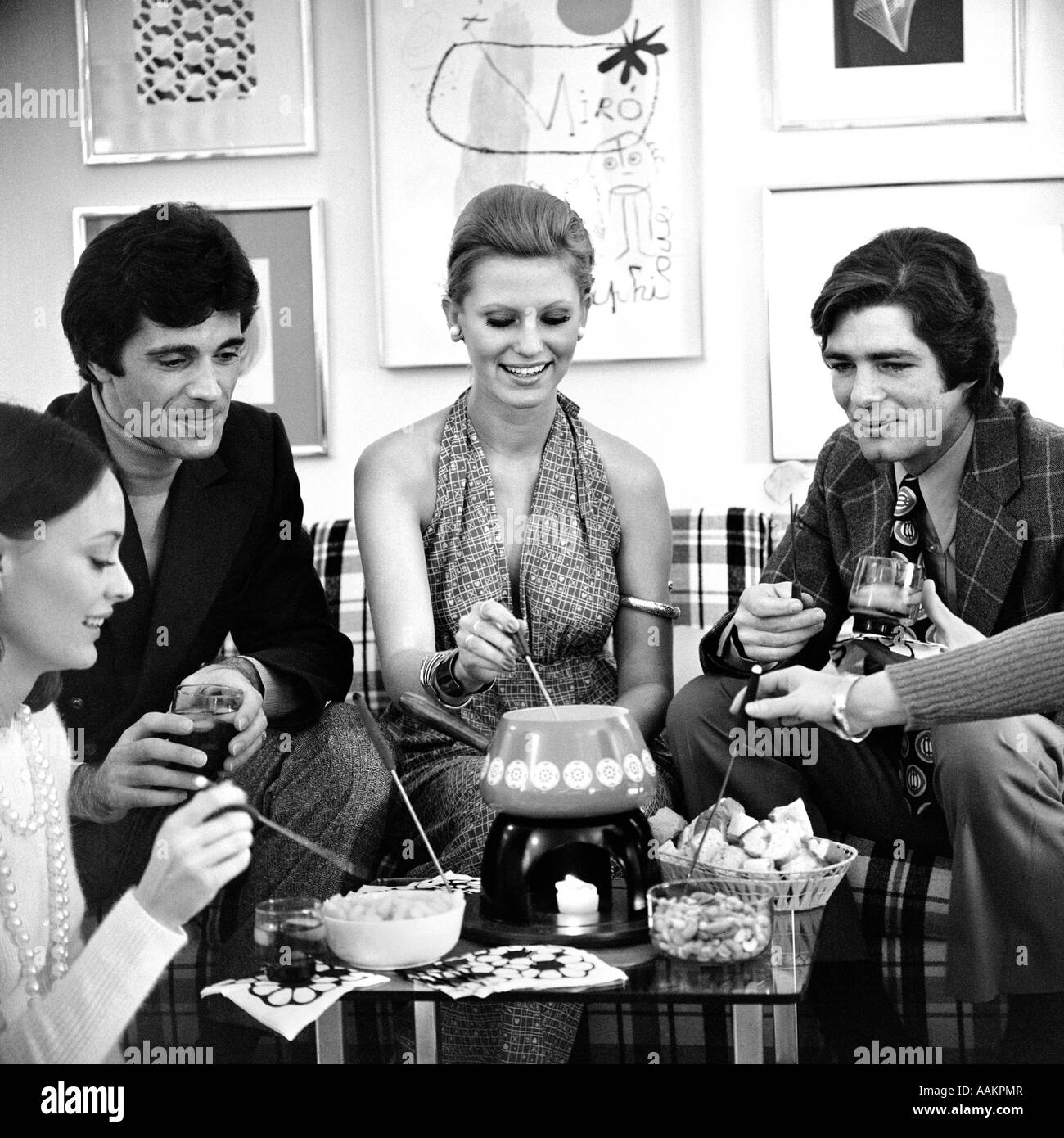 1970ER JAHREN FONDUE-PARTY MIT MEHREREN PAAREN Stockfoto