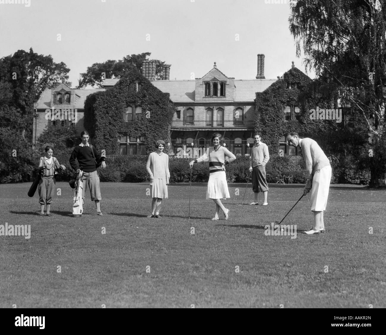 1920ER JAHREN ZWEI FRAUEN VIER MÄNNER OBERSCHICHT SPIELEN GOLF AUF DEN BERKSHIRES, JAGD UND OUTDOOR COUNTRY CLUB Stockfoto