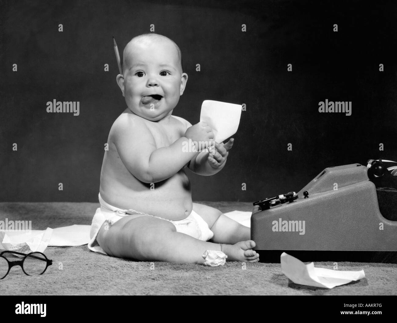 1960ER JAHRE BABY AM ADDING MACHINE Stockfoto