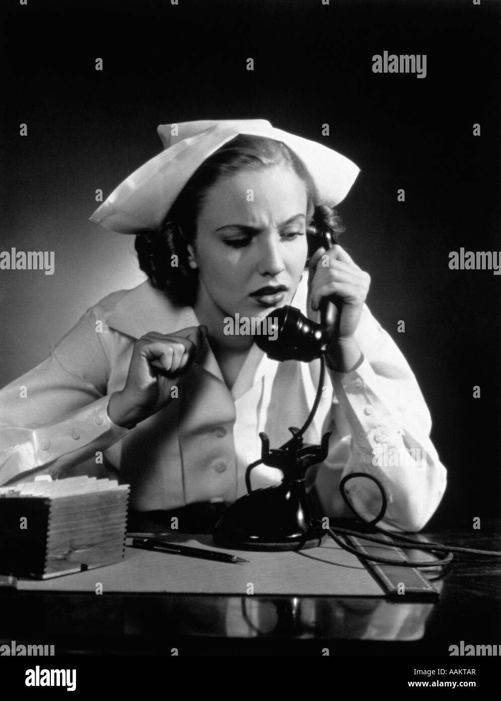 1930S 1940S BETROFFENEN KRANKENSCHWESTER AM TELEFON SPRECHEN Stockfoto
