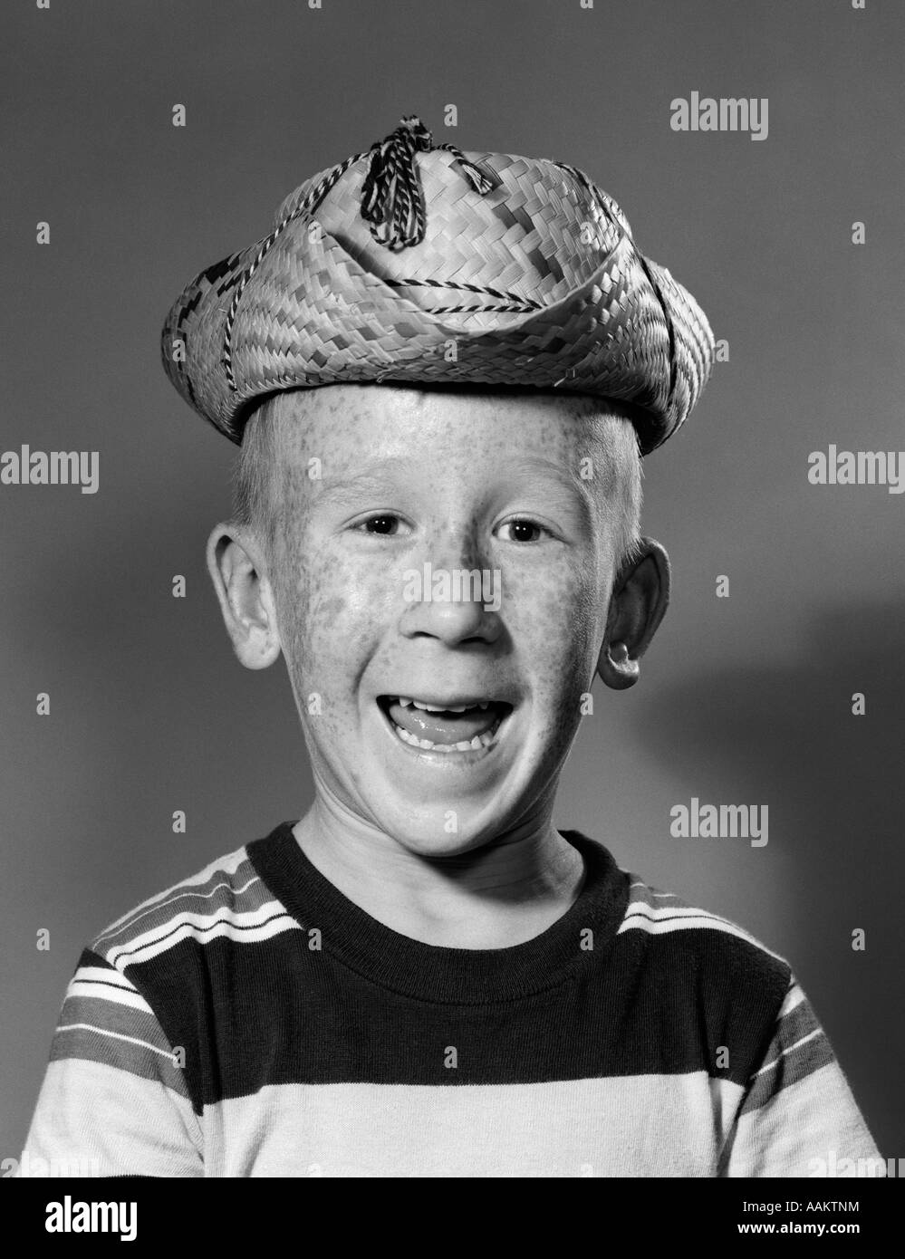 1950ER JAHREN LÄCHELND GOOFY FRECKLE KONFRONTIERT JUNGE TRAGEN ALBERN ZU KLEIN COWBOY-STROHHUT Stockfoto