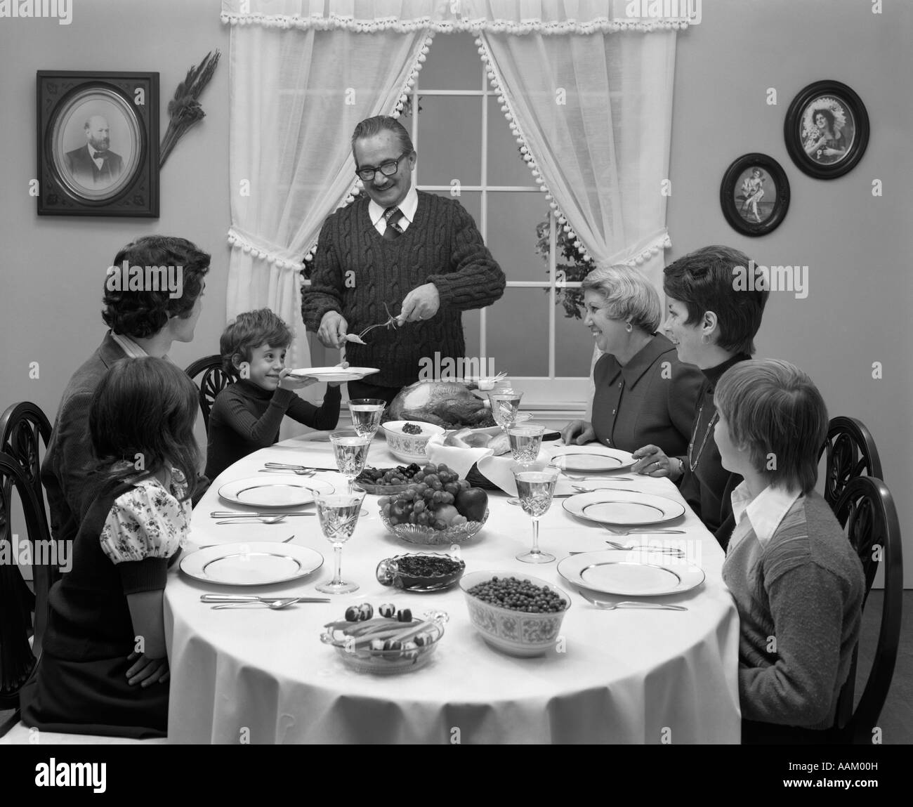 1970ER JAHREN DREI-GENERATIONEN-FAMILIE AN THANKSGIVING TÜRKEI TÜRKEI TISCH SITZEN Stockfoto