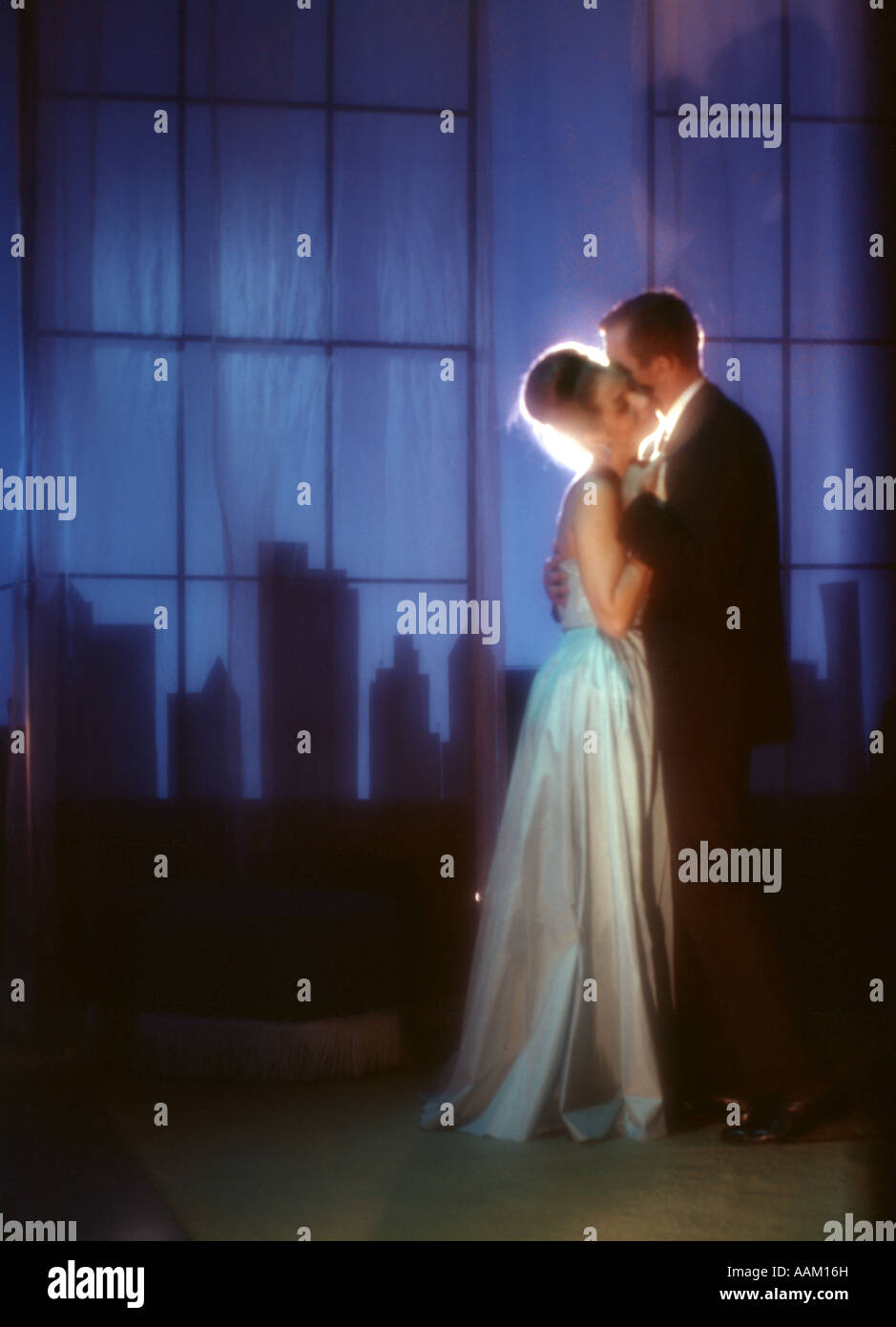 1970ER JAHREN PAAR FORMALEN FRAU LANGE WEIßE KLEID NACHT STADT SKYLINE TANZ DATUM AUF DER DACHTERRASSE PENTHOUSE NACHTCLUB ROMANZE Stockfoto
