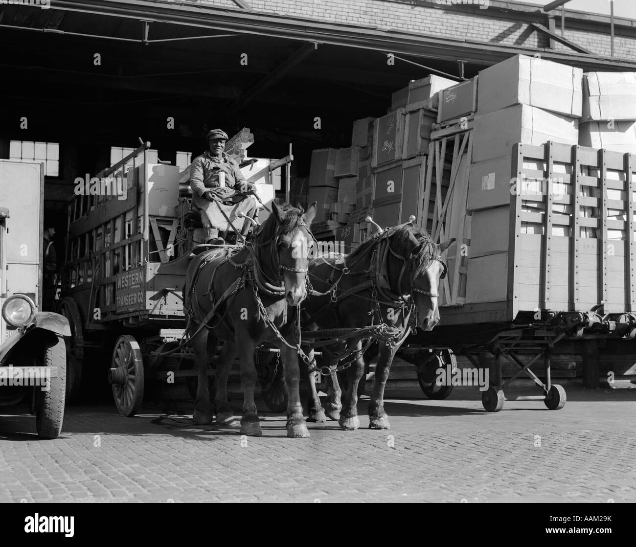 WENDE DES JAHRHUNDERTS AFROAMERIKANISCHE MENSCHEN ZIEHEN WAGEN, GEZOGEN VON ZWEI PFERDEN AUS LKW-TERMINAL Stockfoto