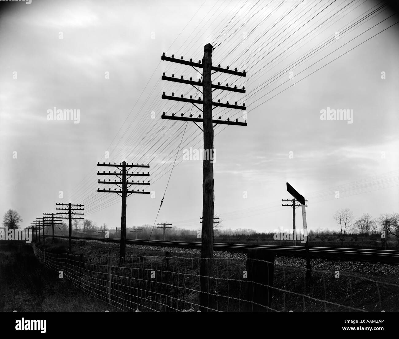 1930S 1940S ZU VERFOLGEN, TELEGRAPH UND TELEFONMASTEN UND DRÄHTE ENTLANG EISENBAHNSCHIENEN VORFAHRT Stockfoto