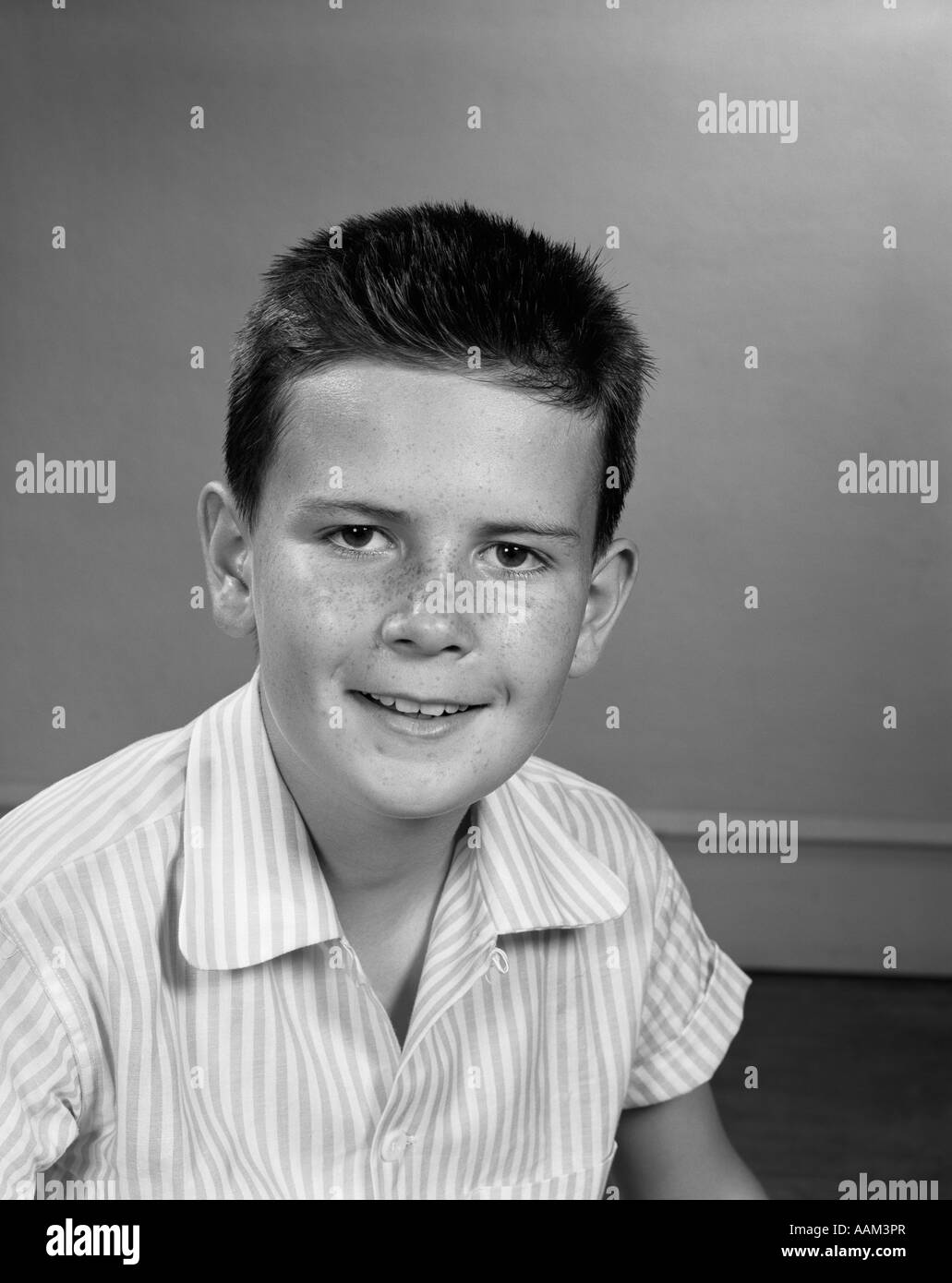 1960S 1950S LÄCHELND PRE-TEEN BOY SOMMERSPROSSIGE NASE LANG CREW CUT HAARE STREIFEN HEMD Stockfoto