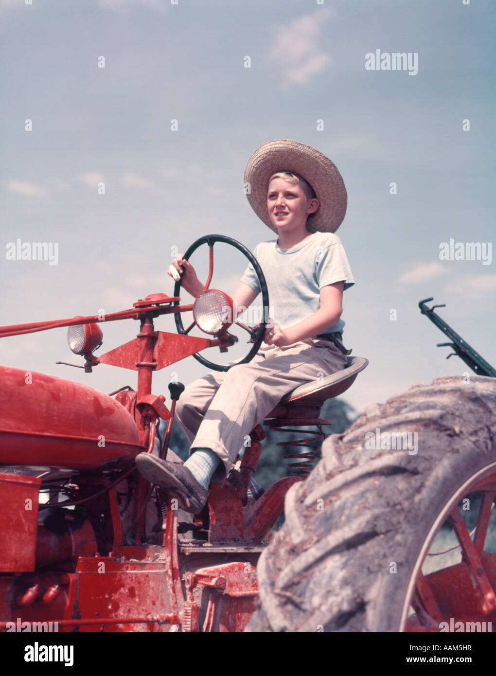 1950ER JAHREN BAUERNJUNGE MIT STROH HUT UND TRAKTOR FAHREN ...