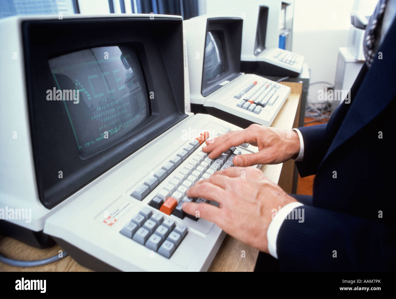 1980ER JAHRE MÄNNLICH HÄNDE AUF DER TASTATUR VON TEXAS INSTRUMENTS COMPUTER Stockfoto