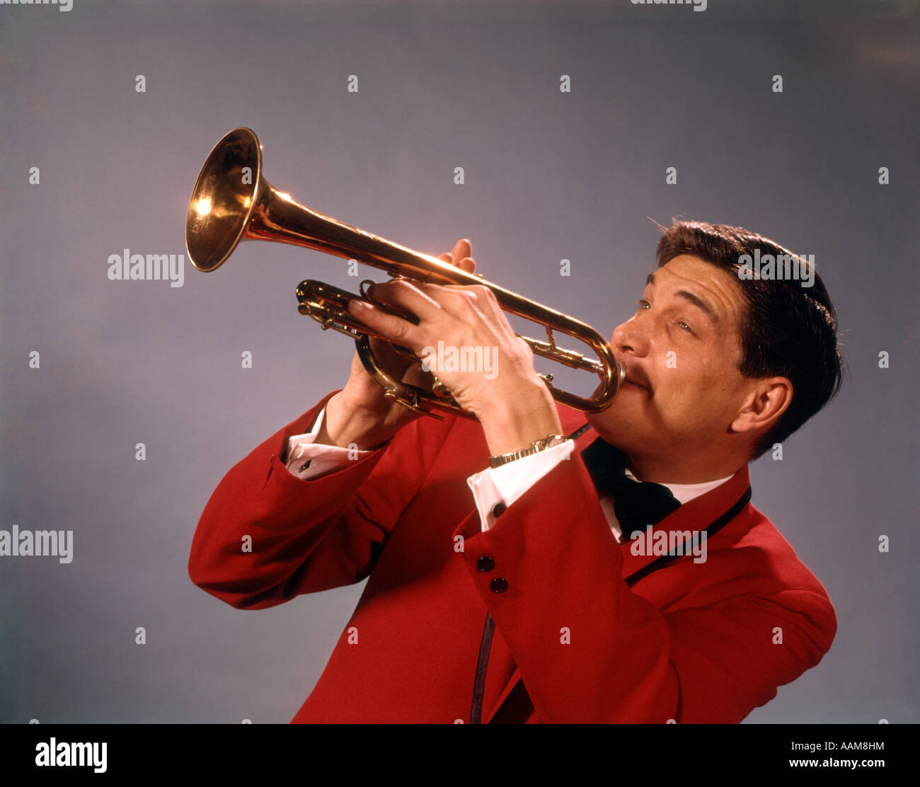 1960S 1970S MANN SPIELT TROMPETE IN ROTE JACKE MUSIKER TROMPETEN INSTRUMENT JAZZ MUSICALDARSTELLER ENTERTAINER Stockfoto
