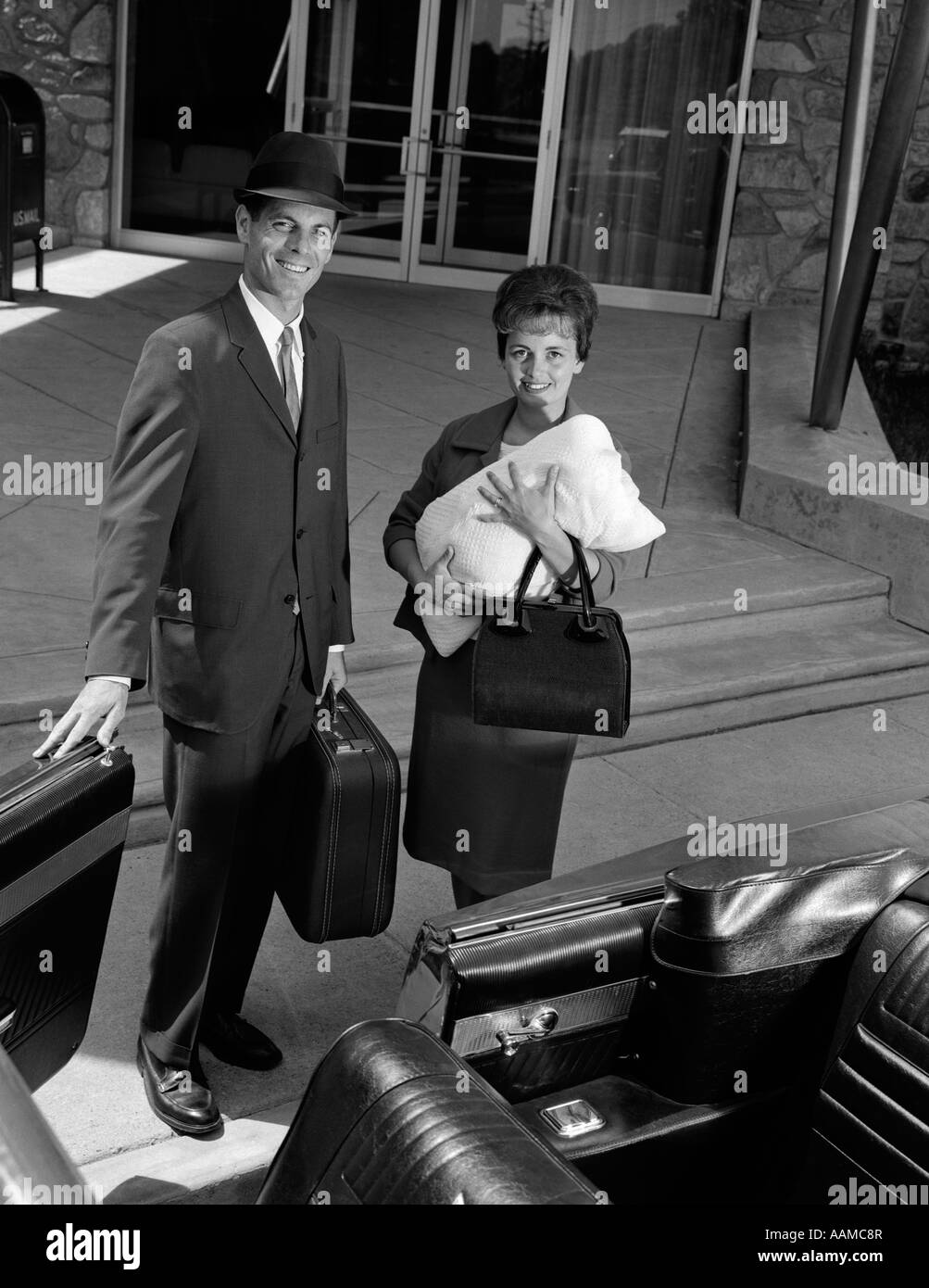 1960ER JAHREN PAAR UNTER NEUE BABY NACH HAUSE VOM KRANKENHAUS VATER HOLDING CABRIO AUTOTÜR GEÖFFNET FÜR MUTTER Stockfoto