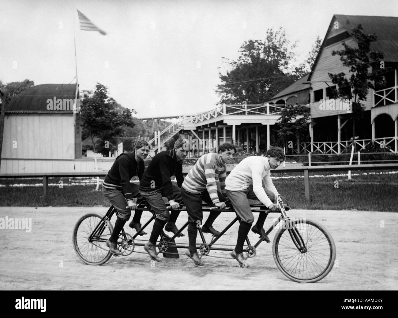 1890S 1900S PLATZ VIER JUNGE COLLEGE MÄNNER REITEN HAUSIEREN VIER RENNRAD Stockfoto