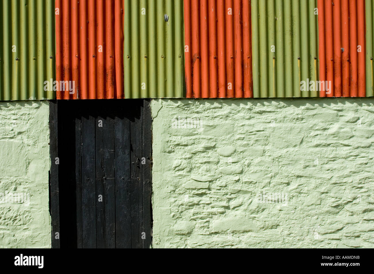 Grün und Orange bemalten Wand und Wellpappe Eisen Verkleidung Bauernhof Gebäude Schuppen Pontrhydfendigaid Ceredigion Wales UK Stockfoto