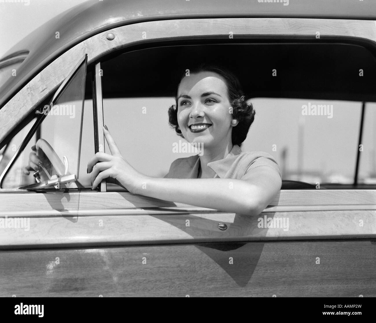 1950ER JAHREN FRAU FAHREN LÄCHELN AUTO Stockfoto