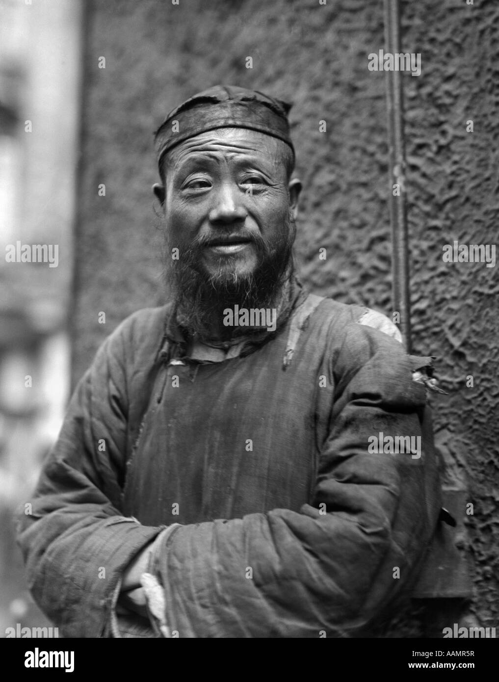 1920S 1930S PORTRAIT ALTE ÄLTERER MANN CHARAKTER CHINESISCHE PRIESTER ZERSCHLISSENER KLEIDUNG BART HAT SHANGHAI CHINA Stockfoto