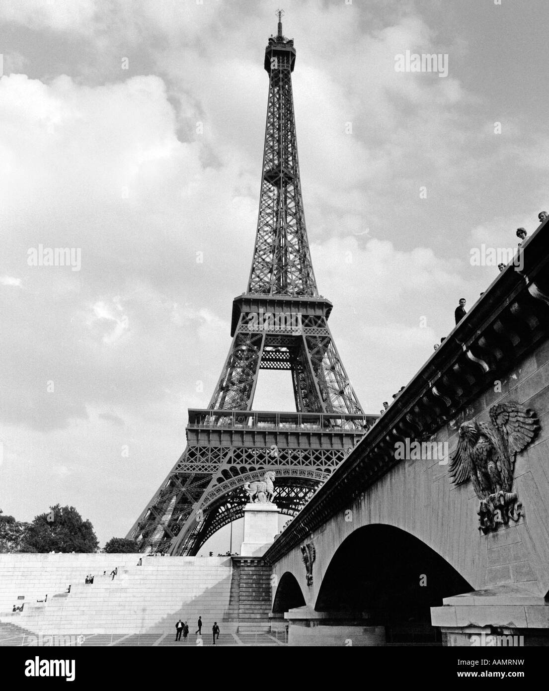 1970ER JAHRE EIFFELTURM MIT MENSCHEN TREPPENSTEIGEN & AUF BRÜCKE FÜHREN, IM VORDERGRUND Stockfoto