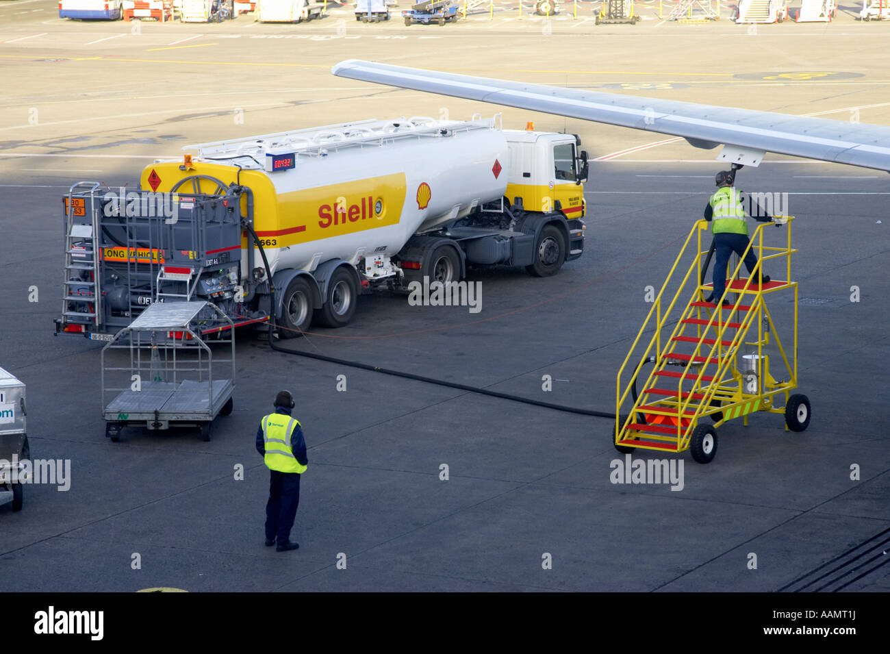 Schale Flugzeug Treibstoff Tanker Treiber auf mobile Schritte prüfen Betankung Rig als Bodenpersonal Uhren Betankung einer Boeing 757 Stockfoto