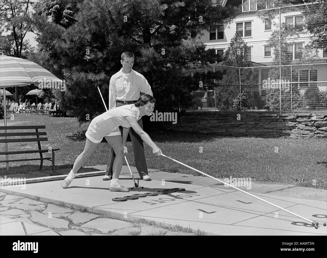 1950ER JAHREN JUNGEN UND MÄDCHEN SPIELEN DECK SHUFFLEBOARD Stockfoto