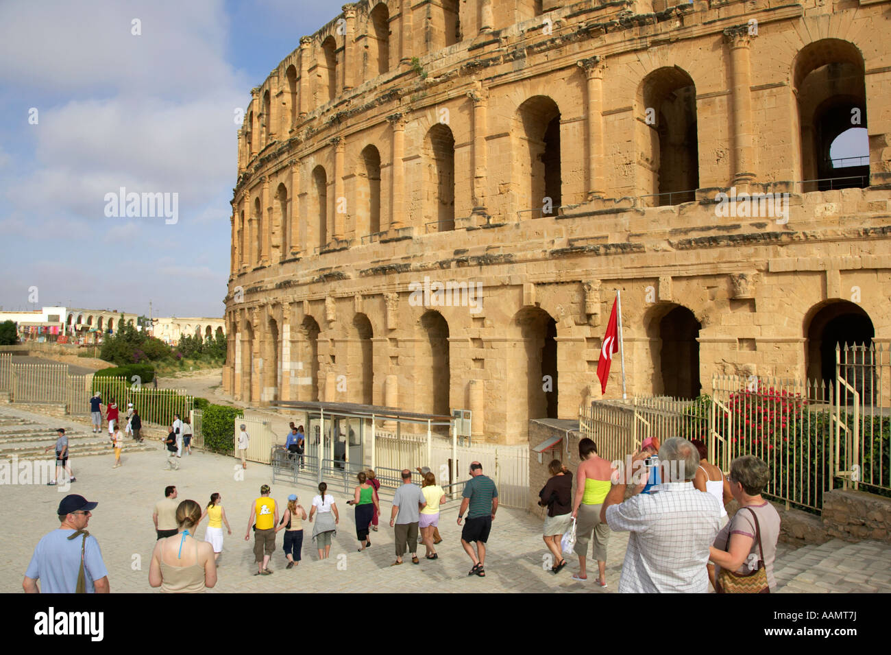 Touristen gehen Sie die Schritte in Richtung Haupteingang des alten römischen Colloseum gegen blauen Wolkenhimmel el Jem Tunesien vertikal Stockfoto