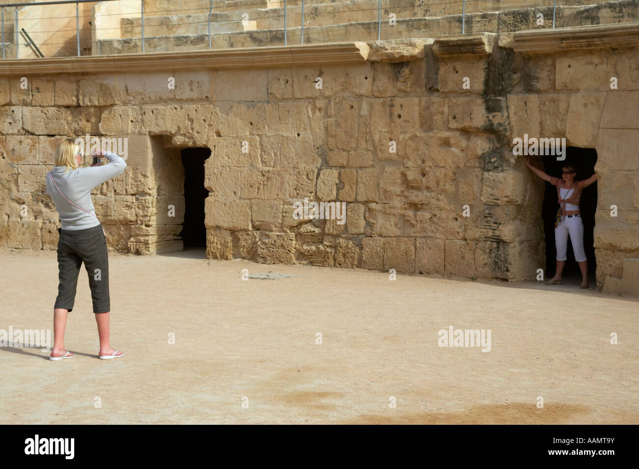 zwei weibliche Touristen fotografieren auf dem Boden der Arena der Hauptarena des alten römischen Kolosseum in el Jem Tunesien Stockfoto