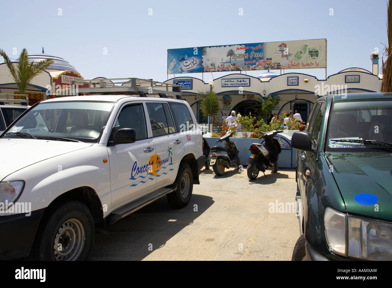 4 x 4 Tourist Tour Fahrzeuge und einheimischen Mofas außerhalb Straßencafé-Shop auf der Autobahn in Tunesien Stockfoto