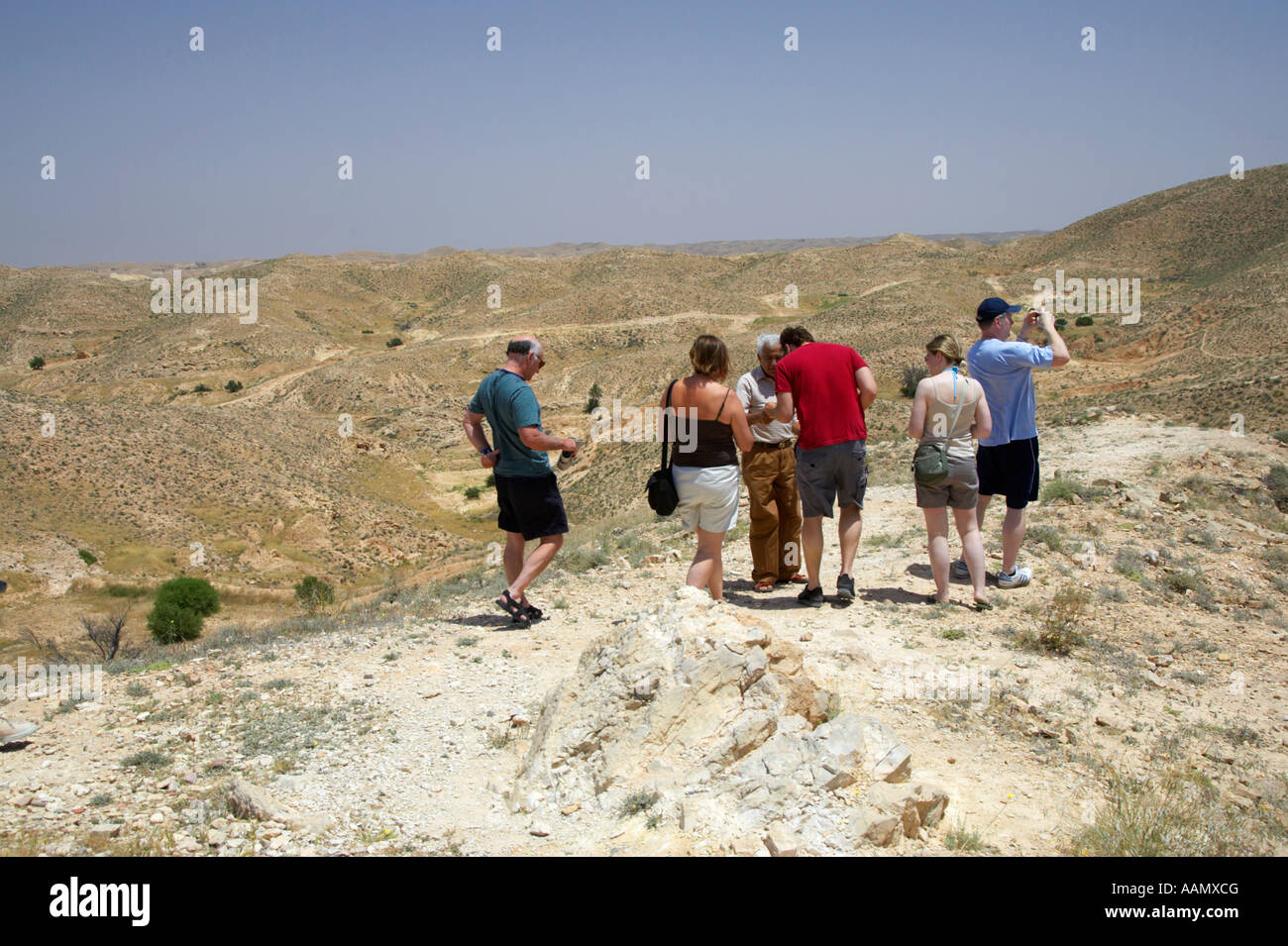 Gruppe von britischen Touristen und Tour Guide Stand auf Felsvorsprung auf der Suche in der Wüste Matmata Tunesien Stockfoto