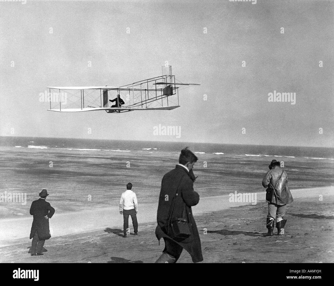 EINER DER GEBRÜDER WRIGHT FLIEGEN GLEITSCHIRM DURCH DEN OZEAN UND DIE ZUSCHAUER AUF STRAND UNTER KITTY HAWK NORTH CAROLINA USA Stockfoto