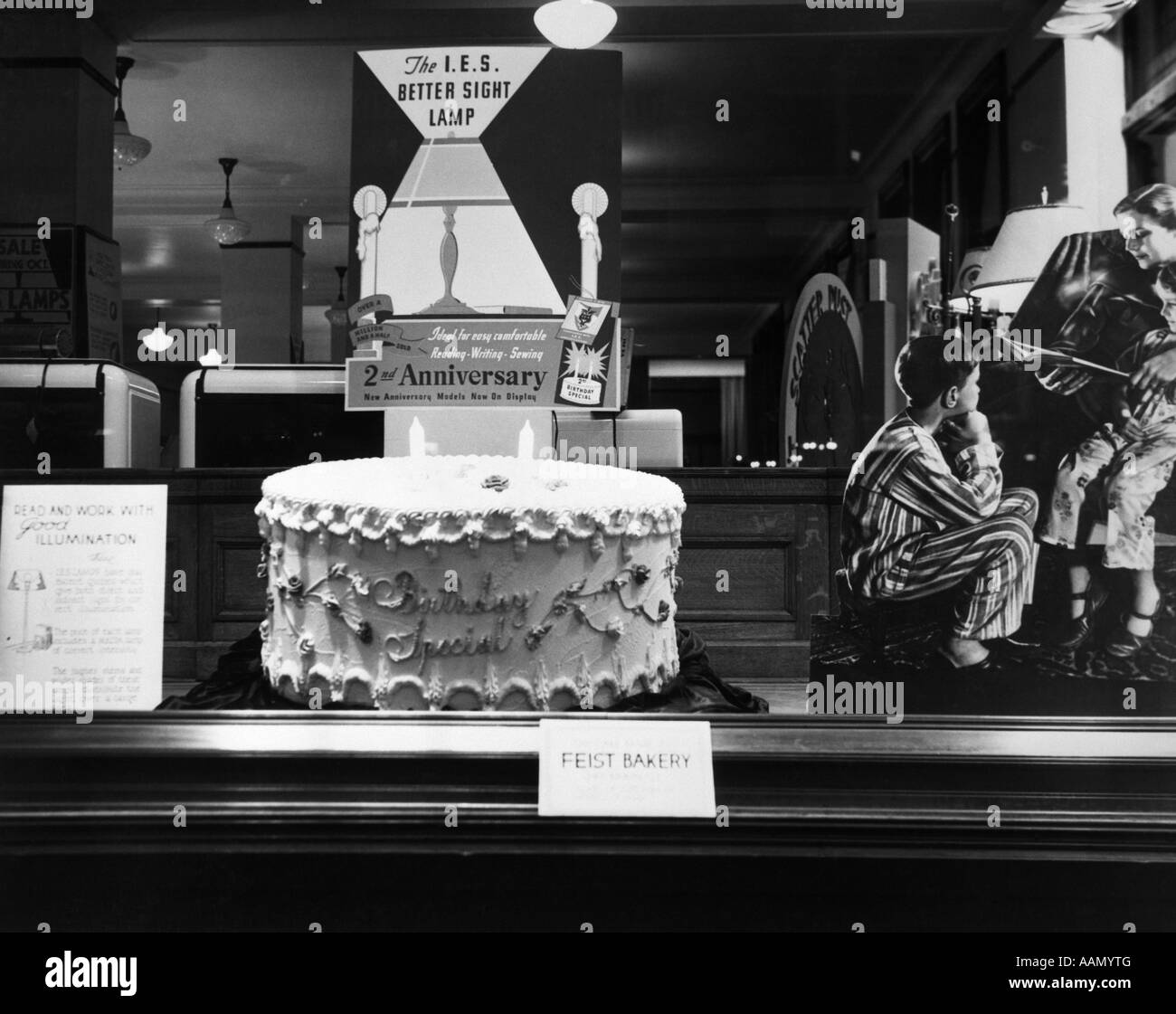 1930ER JAHREN FENSTER ANZEIGE ELEKTRISCHE LAMPE SPEICHERN 2. JAHRESTAG GEBURTSTAG KUCHEN EINZELHANDEL WERBUNG HACKENSACK NJ Stockfoto