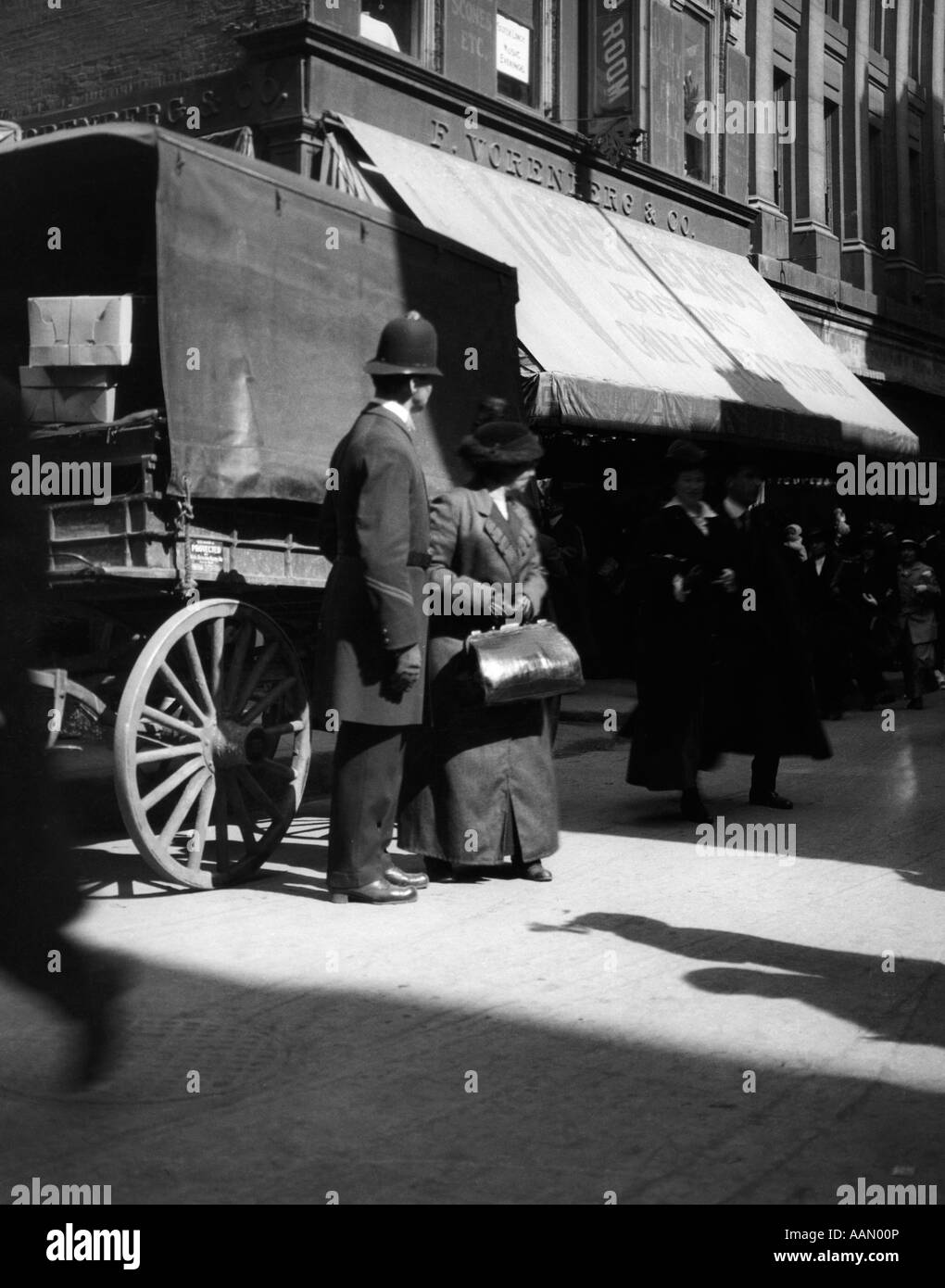 1900S 1910S POLIZEI POLIZIST UND FRAU FUßGÄNGERZONE IN NEW YORK CITY STREET Stockfoto