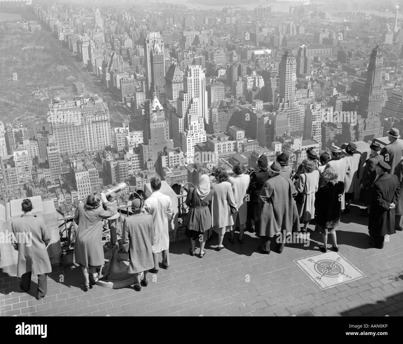 1940ER JAHRE GRUPPE VON TOURISTEN STAND AM ANFANG VON RCA BUILDING LOOKING OUT ÜBER STADT Stockfoto