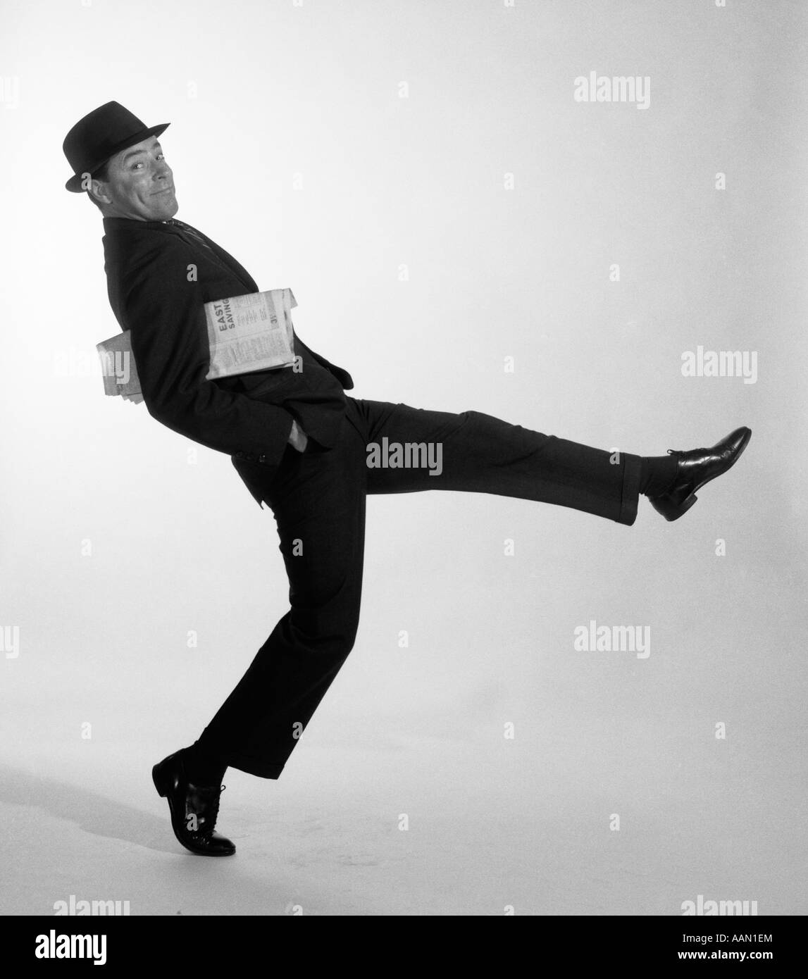 1950ER JAHRE BUSINESS-MANN IN HUT UND ANZUG HOLDING ZEITUNG MACHEN ÜBERTRIEBENER AUSDRUCK Stockfoto