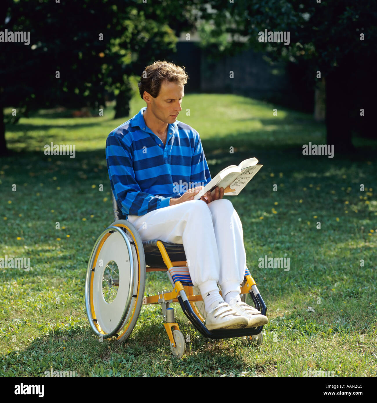 Behinderte Menschen im Rollstuhl ein Buch im Garten Stockfoto